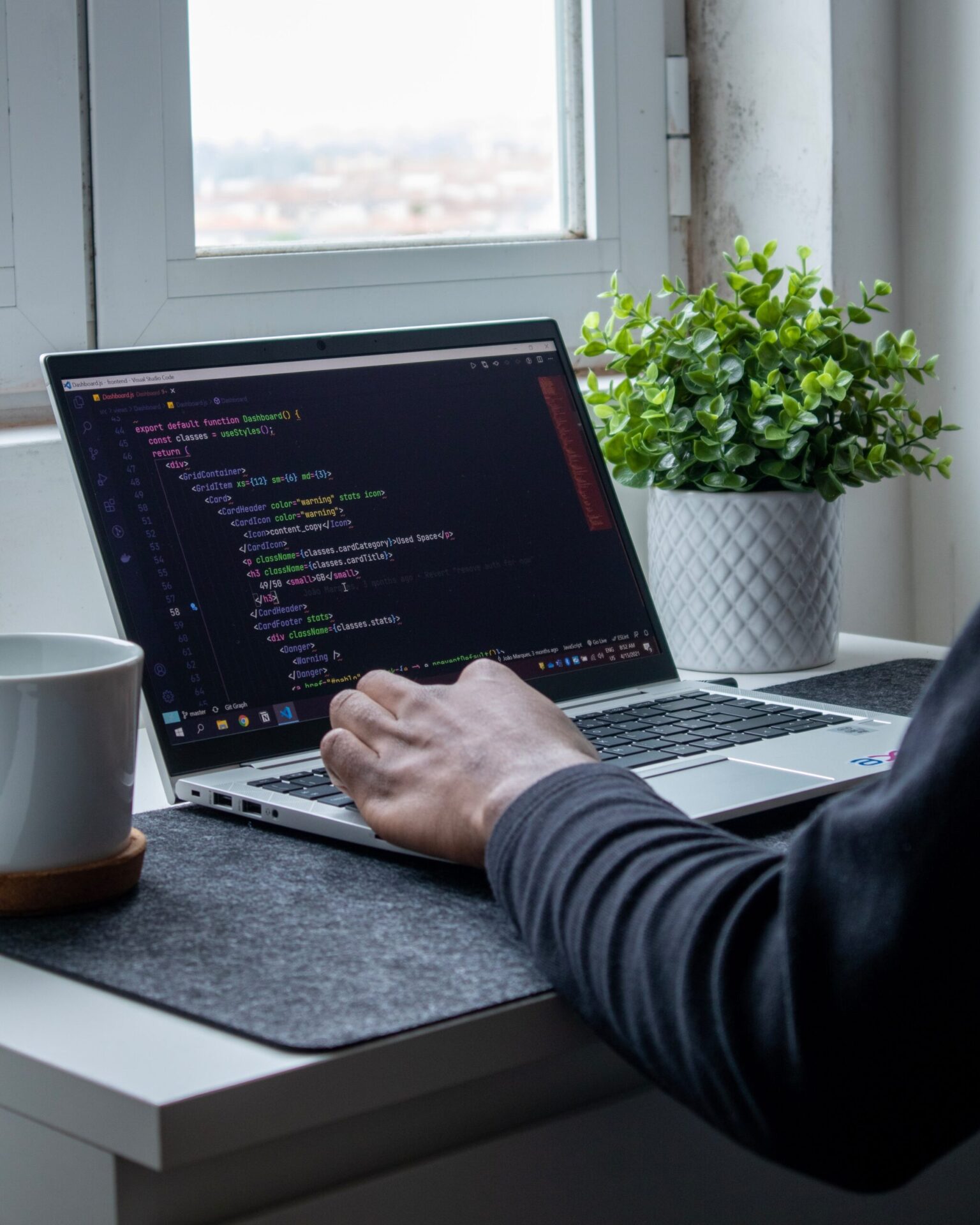 Person working on a laptop with code on screen